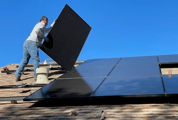 Man installeert zonnepanelen op het dak