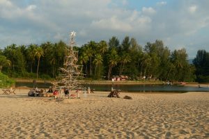 Strand met kerstdecoraties en palmbomen, ideaal decor voor een ontspannen vakantie met kinderen