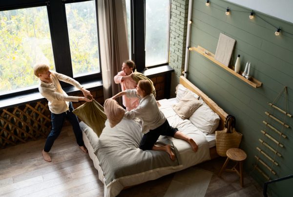 kinderen vechten met kussen op een bed