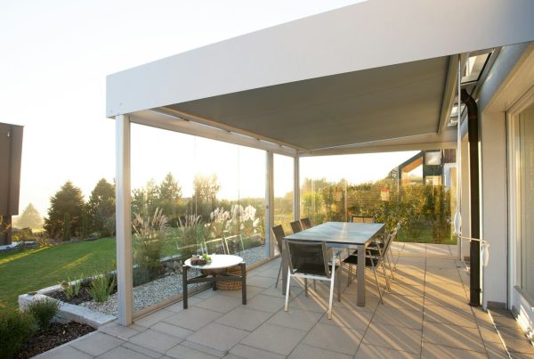 Strakke beschutte zitplek met glazen wanden en overkapping, ideaal voor gebruik bij verschillende weersomstandigheden.