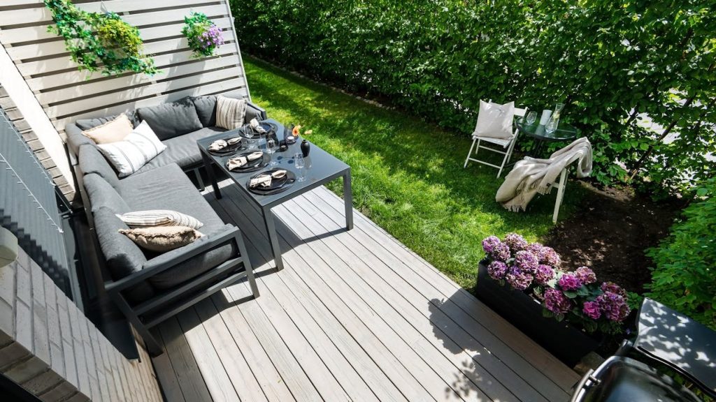 Compacte zithoek op terras met bank en tafel in een kleine tuin inrichten met efficiënte indeling