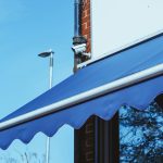 Blauwe zonwering boven een raam